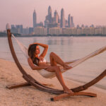 girl sitting in hammock with view of Dubai Marina in the background