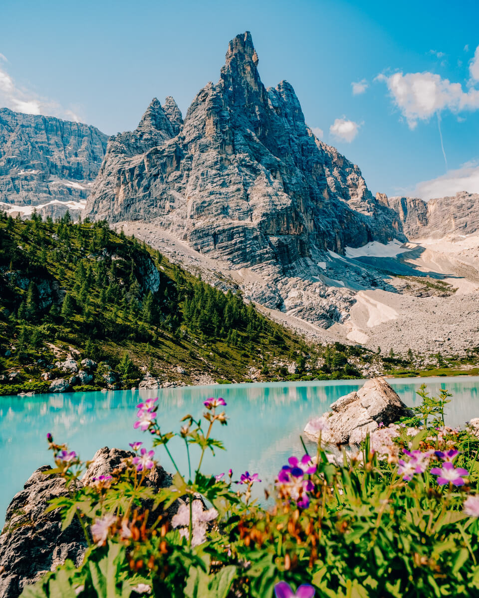 the Lago di Sorapis- one of the best places to visit in the dolomites - a blue lake with a beautiful mountain backdrop