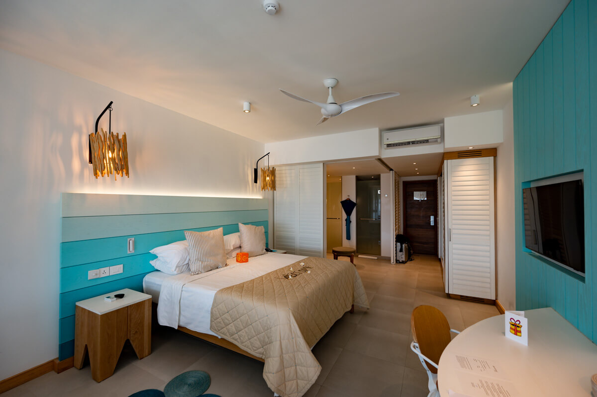a deluxe room of the C Mauritius resort with a huge bed, desk and open bathroom