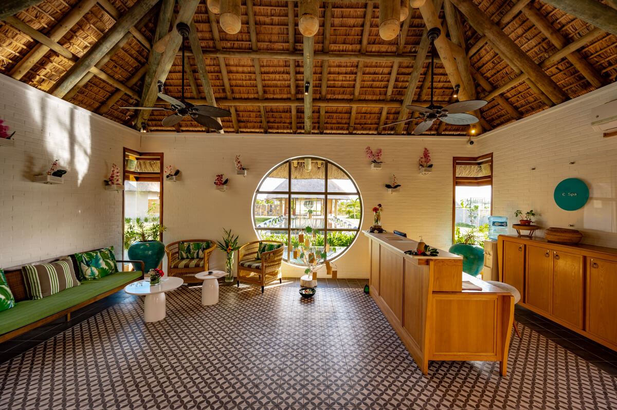 the inside of the main building of the spa area at the C Mauritius resort with many wooden elements and furniture