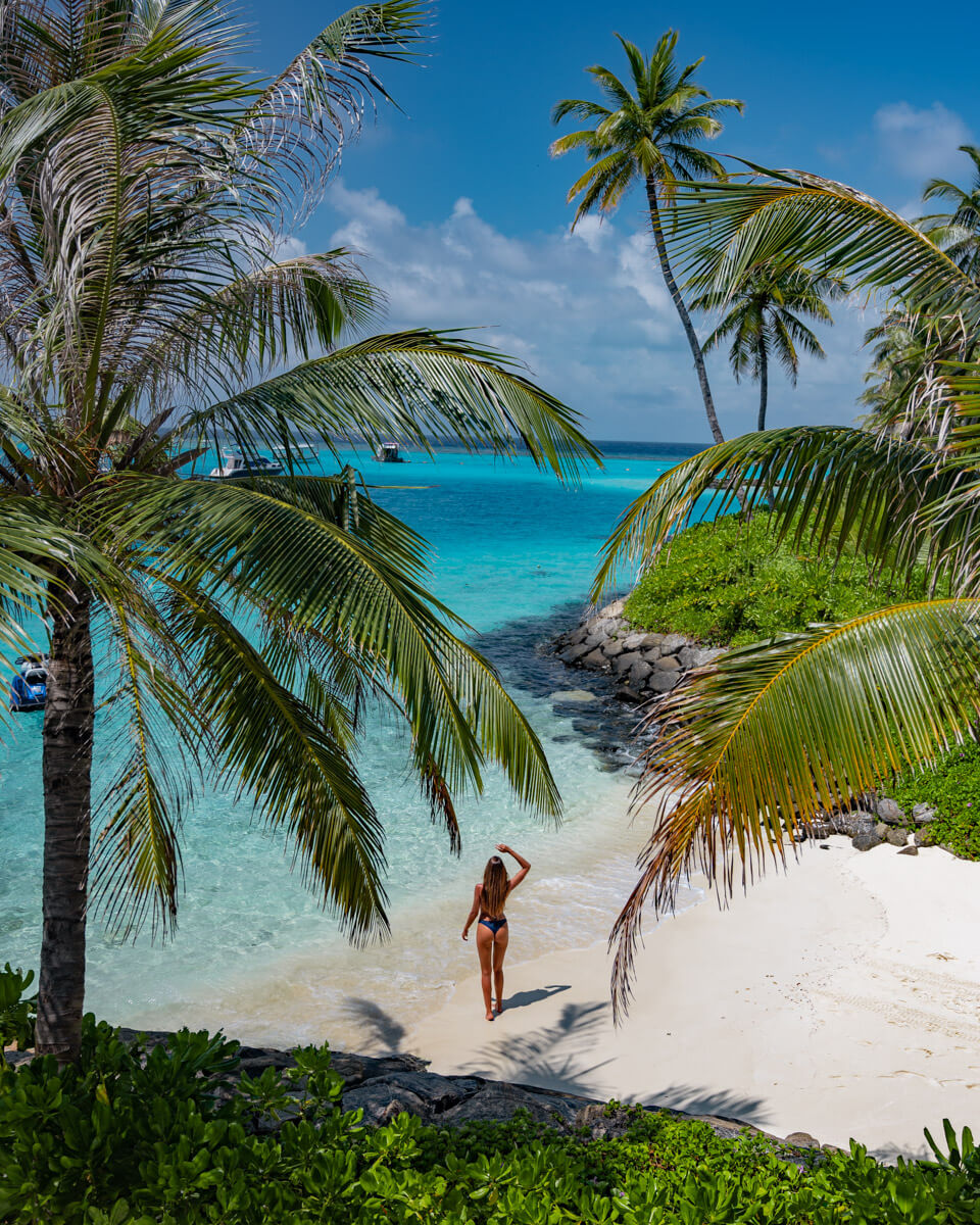 a girl standing at a beautiful paradisiac bay in the maldives located on the Jumeirah Maldives Olhahali Island