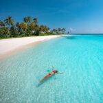 girl floating in clear and blue water in a lagoon in the maldives, paradise island at the Jumeirah Maldives Olhahali Island