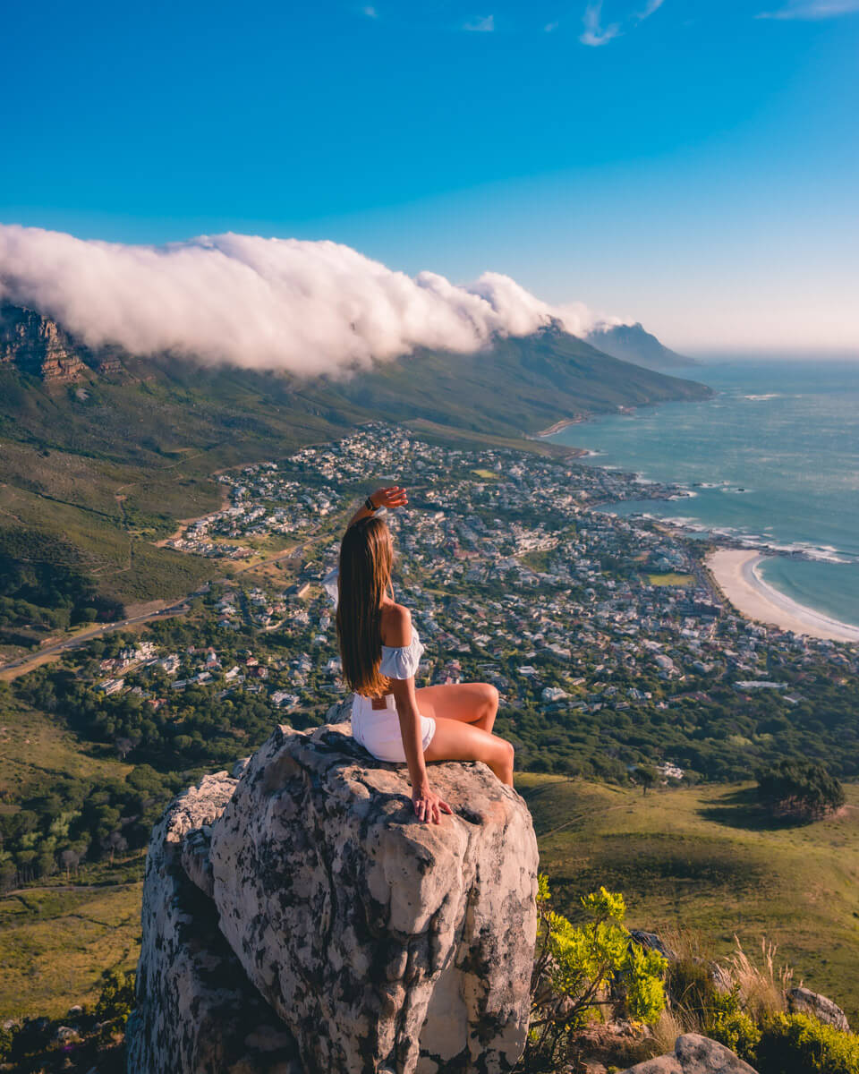 sitting on a rock at the top of the lions head, overlooking Cape Town in South Africa