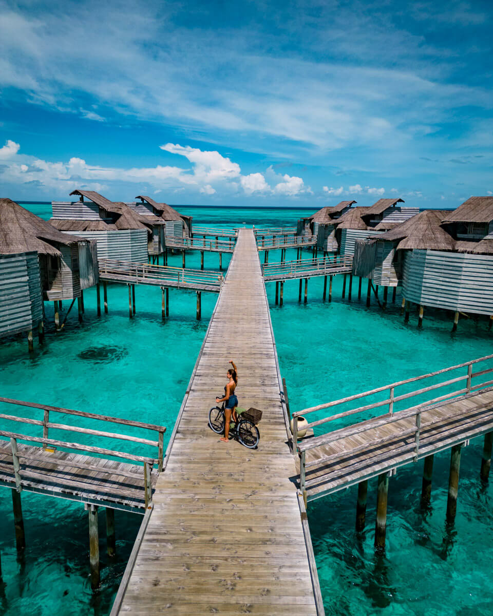 Bicycle ride on a jetty over the turquoise blue lagoon of the Six Senses Laamu Maldives