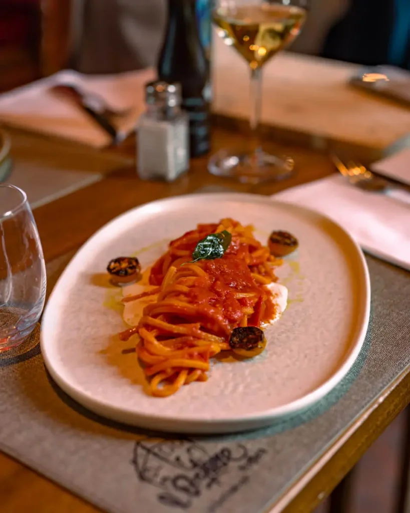 pasta with tomato sauce and a glass of wine, a trattoria which is one of the best restaurants in Florence, Italy
