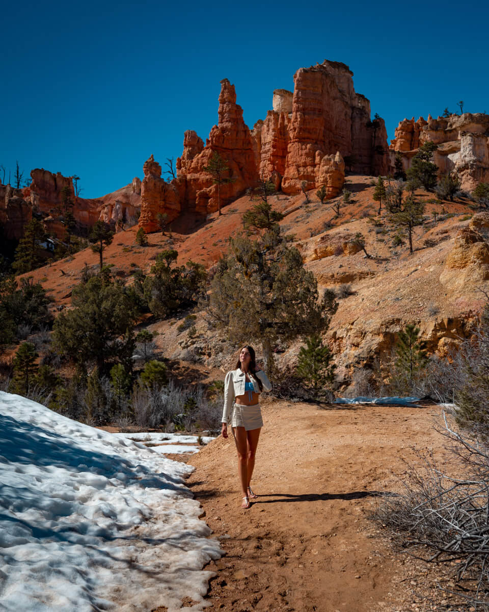 walking in front of a rock formation in the Bryce Canyon national park with snow