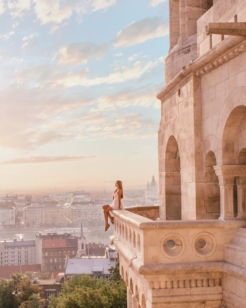 overlooking the city and the sunrise sitting on a balcony on top of the Fisherman's bastion which is one of the most famous sights in Budapest