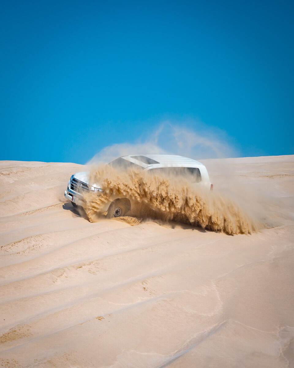 dune bashing in a white jeep at the desert of Qatar